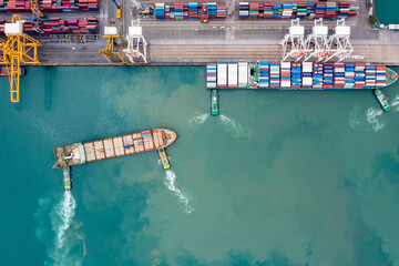 container ship and tug boat to quayside for load and unload container via crane for logistics, import export goods internationally around the world, including Asia Pacific and Europe