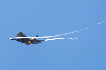 Very close tail view of a F-35A Lightning II  with afterburner on and condensation streaks