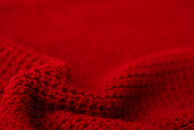 Knitted Surface Of Woolen Things As A Background. Close-up Of Soft Fabric Red Color Knitted Patterns Texture. Warm Winter Clothing. Background Textile Surface With Copy Space For Text.