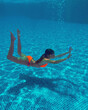 young girl in the pool underwater close-up. holiday at the resort;