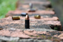 9mm Pistol Bullets And Bullet Shells On Brick Floor, Soft And Selective Focus, Concept For Searching A Key Piece Of Evidence In A Murder Case At The Scene.