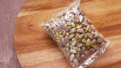 Wall Mural - nantural pistachios nut in a plastic packet on wood 