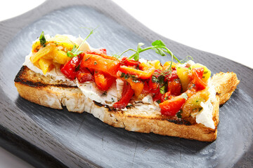 Wall Mural - Delicious bruschetta with baked peppers close up view