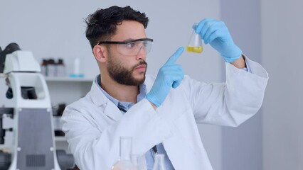 Aufkleber - Serious male scientist analyzing liquid in a beaker in a laboratory. Professional biochemist testing yellow fluid, conducting an experiment to find a cure for a virus in a medical research facility