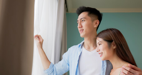 Canvas Print - happy asian couple watching outside