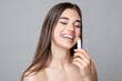 Young beautiful happy smiling woman applying lipstick or lip balm, skin and lips care, Chap protection