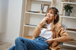 © SHOTPRIME STUDIO - Dreaming happy young blonde lady in warm sweater in headphones looks aside listen fav songs sitting in armchair at modern home interior. Music time Relaxing Cool playlist Concept. Copy space