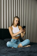 © F8  \ Suport Ukraine - Relaxed woman at home reading a text message in her bedroom