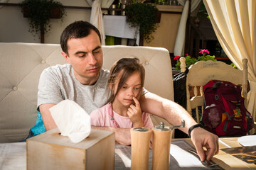 Wall Mural - Father showing her daughter menu in outdoor area of restaurant in summer