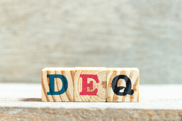 Sticker - Alphabet letter block in word DEQ (Abbreviation of Delivered Ex Quay) on wood background