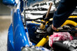 © Mihail - male detailer with brush cleaning the engine bay