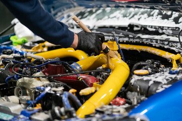 Wall Mural - male detailer with brush cleaning the engine bay