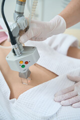 Canvas Print - Procedure for laser removal of neoplasms on the abdomen in a cosmetology clinic