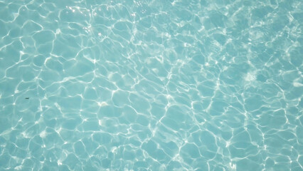 Poster - Water in swimming pool rippled water detail background. Water in swimming pool with sun reflection. Blue swimming pool rippled water detail