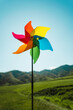 Symbol of clean green energy, pinwheel ibackground of the sky and a green landscape