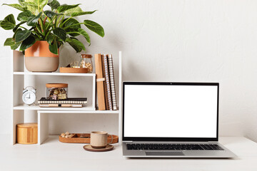 Empty laptop screen, desktop organizer with desk shelves and office supplies. Back to school, home office, begining of studies concept. Mockup, template