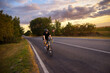 © Solid photos - Young sports man cycling with bicycle on the road in summer