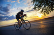 © Solid photos - Young sports man cycling with bicycle on the road in summer