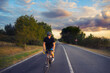 © Solid photos - Young sports man cycling with bicycle on the road in summer