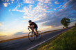© Solid photos - Young sports man cycling with bicycle on the road in summer
