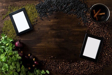 Dark wooden background with a culinary theme. The view is strictly from above. A scattering of pine nuts, black and green beans, dried red onions, two empty frames for photos or text.