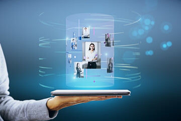 Fototapete - Close up of hand holding tablet with abstract digital cylinder picture hologram on blue background. Computer, technology, innovation and media.
