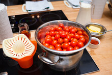 A Set Of Raw, Fresh Foods Before Cooking. A Bowl Of Washed Cherry Tomatoes, A Juicer, Butter, Red Sweet Paprika Powder, A Jug Of Milk And Paper Towels.
