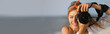 © New Africa - Photographer taking photo with professional camera near sea, space for text. Banner design