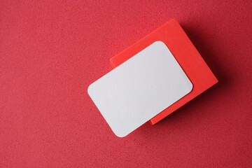Poster - blank business card on pedestal on vivid red background studio