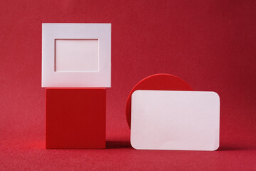 Poster - blank business card on pedestal on vivid red background studio
