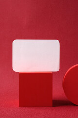 Poster - blank business card on pedestal on vivid red background studio