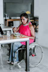 Wall Mural - Latin transgender woman on wheel chair working with computer at the office in Mexico Latin America	