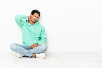 Wall Mural - Caucasian handsome man sitting on the floor with neckache