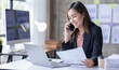 © David - Young Business asian woman talking on smartphone and working in office. Asian female Business sitting at his workplace.