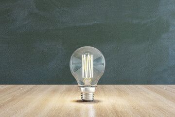 Wall Mural - Close up of illuminated light bulb with filament on wooden and chalkboard wall background. New idea and innovation concept. 3D Rendering.