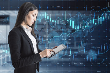 Wall Mural - businesswoman with tablet and creative glowing forex chart hologram with map on blurry office interior background. Stock, market and invest concept. Double exposure.