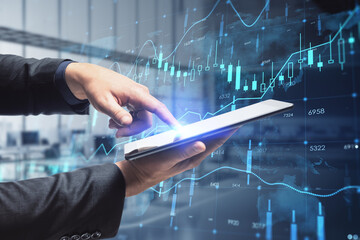 Aufkleber - Close up of businessman hand pointing at tablet with creative glowing forex chart hologram with map on blurry office interior background. Stock, market and invest concept. Double exposure.