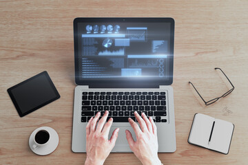 Aufkleber - man hands using laptop keyboard with glowing business chart hologram on screen at wooden desktop with coffee cup, supplies and tablet or smartphone. Technology, work, finance and innovation concept.