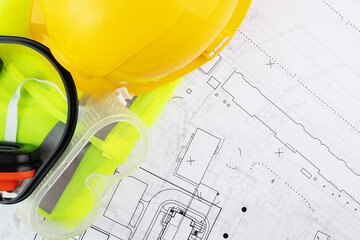 Wall Mural - construction goggles, engineer's helmet, builder's industrial clothing, occupational safety in construction on background of architectural drawings