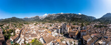 Spain, Balearic Islands, Soller, Helicopter Panorama Of Church Of Saint Bartholomew And Surrounding Houses With Serra De Tramuntana Mountains In Background