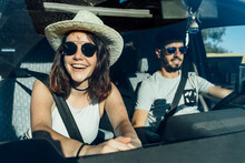 Happy Woman Wearing Hat Sitting In Van With Man