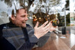 © Westend61 - Smiling businessman doing video call with girlfriend on smart phone in cafe
