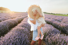 Mother And Daughter Covering Face With Hat In Lavender Field