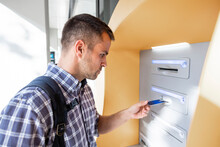 Mature Man Inserting Credit Card Into ATM Machine