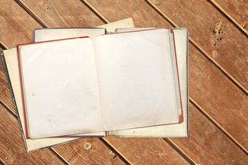 Sticker - Old open books with empty pages on wooden boards. Opened vintage book with blank page on wood plank