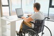 © Serhii - Positive elderly woman in wheelchair working on laptop, IT freelancer, online