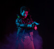 © Ulia Koltyrina - A guy in a cyberpunk image, aiming a gun at someone. a futuristic character. A young man in neon lighting on a black background