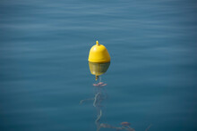 A Yellow Beacon Buoy In The Sea For Beach Marking And Cross Channel Limits With Blue Sky And Fish Underwater, Split View Half Over And Under Water Surface, Mediterranean, Greece