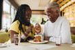 © Jacob Lund - Senior couple eating a cake together in a cafe
