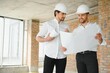 © Serhii - Two Specialists Inspect Commercial, Industrial Building Construction Site. Real Estate Project with Civil Engineer